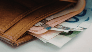 Cartera de cuero abierta con billetes de euro visibles en su interior, simbolizando el cobro de atrasos o ingresos económicos pendientes en el contexto de la declaración de la Renta.
