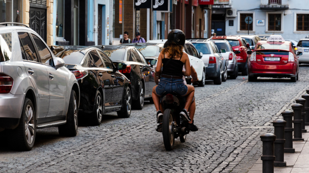 Dos personas circulando en una motocicleta por una carretera.